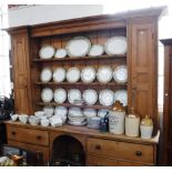 A LARGE EARLY 19TH CENTURY PINE KITCHEN DRESSER, with upper flank panelled cupboards surrounded with