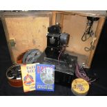 A VINTAGE 1930S 'BABY' PROJECTOR in its original case, with a collection of period films to