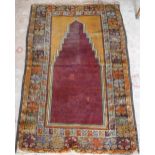 A MUSTARD GROUND PERSIAN PRAYER RUG with red centre 56" long (plus fringes) x 39" wide
