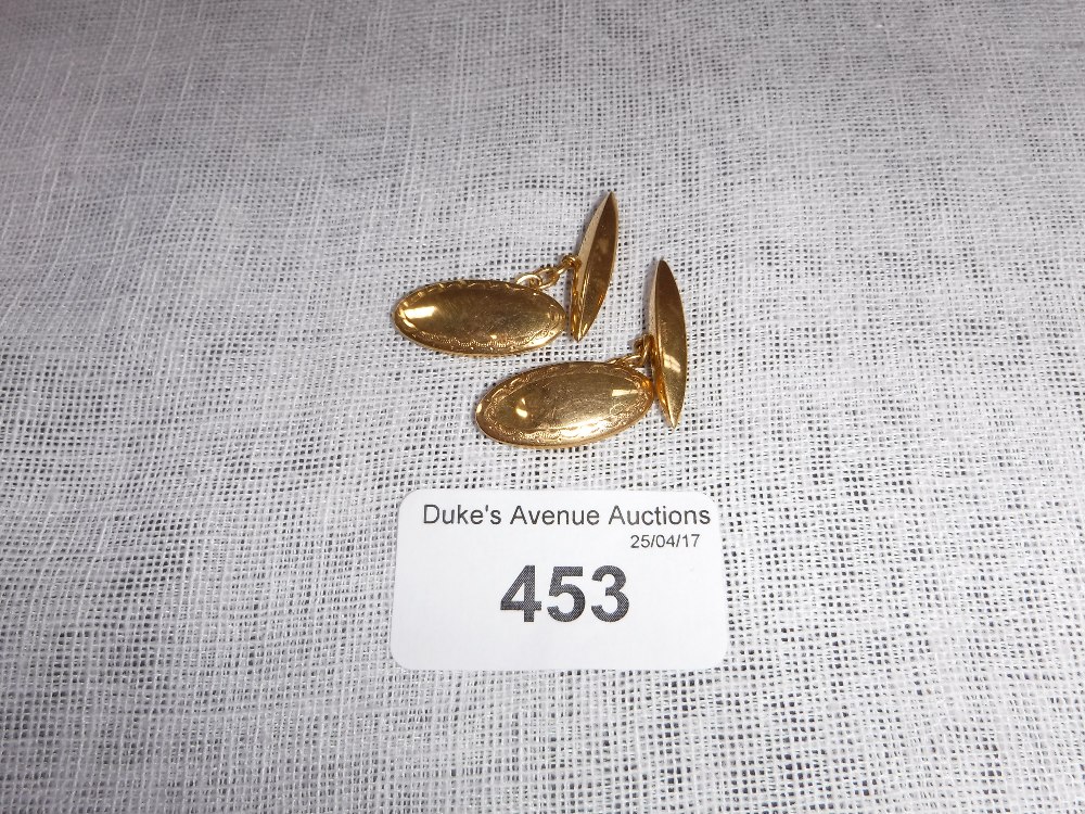 A PAIR OF 9CT YELLOW GOLD OVAL CUFFLINKS with engraved decoration