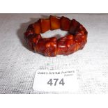 A BEAD BRACELET, each amber type bead carved with a Buddha's head