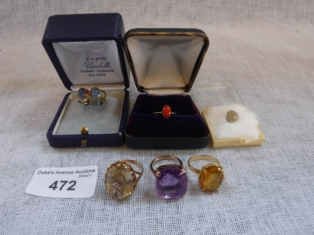 A CORAL AND GOLD SOLITAIRE RING, an amethyst cocktail ring and three other rings with a loose opal