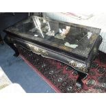 A CHINOISERIE OCCASIONAL TABLE, the rectangular glazed top set with a relief carved scene inset with