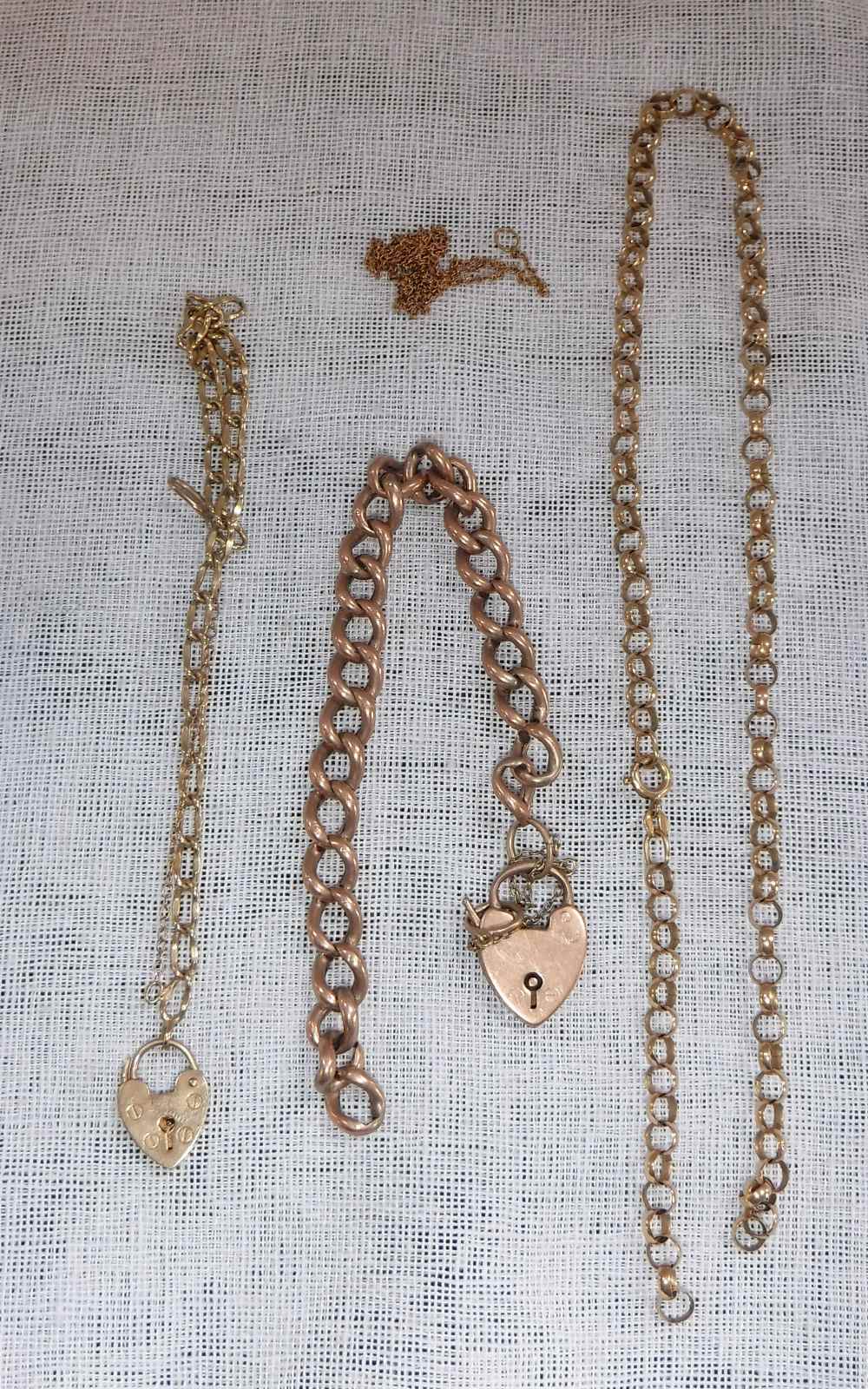 A 9CT ROSE GOLD CURB LINK BRACELET with a heart padlock clasp and a collection of other gold items