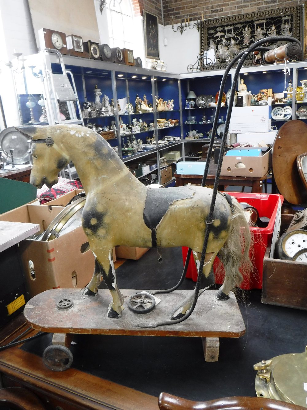 A LATE VICTORIAN PUSH-ALONG HORSE, with original gesso with paint work and metal fittings with