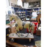 A LATE VICTORIAN PUSH-ALONG HORSE, with original gesso with paint work and metal fittings with