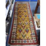 A YELLOW GROUND PERSIAN RUNNER with geometric cream and red border 97" long (plus fringes) x 36"