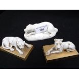 THREE CERAMIC ORNAMENTS of recumbent animals, two on gilt bases