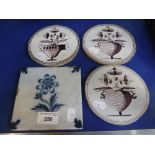 THREE CIRCULAR DELFT TILES with flowers in vases and another
