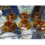 A SET OF SIX AMBER GLASS CUPS AND SAUCERS with gilt metal mounts