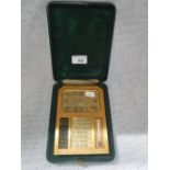 A TABLE CLOCK, calendar and thermometer in a fitted brass case with easel-back, in a fitted