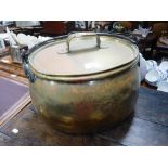 A 19TH CENTURY BRASS CAULDRON with an iron swing-handle, 17.5" wide