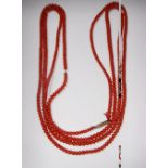 A LONG 'CORAL' BEADED NECKLACE with gold clasp, circa 31"