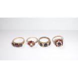 A COLLECTION OF FOUR 9CT YELLOW GOLD DRESS RINGS set with 'garnet'