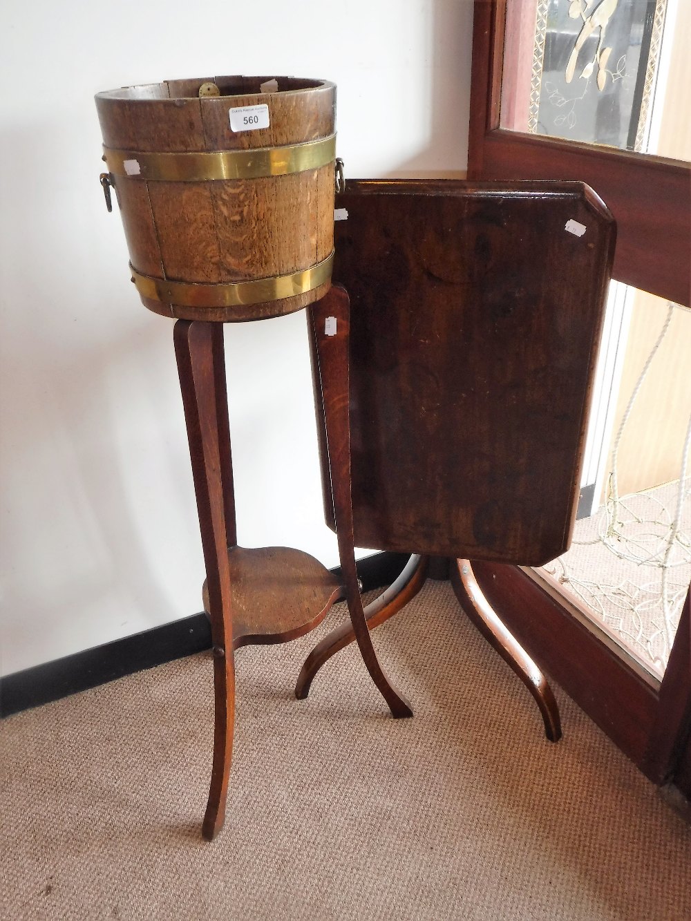 AN EDWARDIAN OAK BRASS BOUND BARREL JARDINIERE ON STAND with tin drip tray and brass-ring handles,