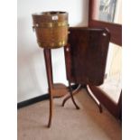 AN EDWARDIAN OAK BRASS BOUND BARREL JARDINIERE ON STAND with tin drip tray and brass-ring handles,