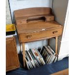 ERCOL: A PALE ELM DESK fitted a long drawer and two small drawers, 27" wide