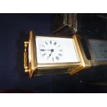 A LATE VICTORIAN/EDWARDIAN GILT BRASS CARRIAGE CLOCK with bevelled glass panels and enamel dial, 4.
