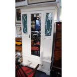 A PAINTED EDWARDIAN WARDROBE with central mirrored door flanked by curtained glass panels,