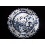 A CHINESE EXPORT PORCELAIN PLATE, painted in blue with landscape decoration, within a floral border,