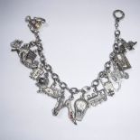 A WHITE METAL CHARM BRACELET adorned with various charms