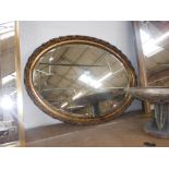 AN OVAL WALL MIRROR within a gilt frame