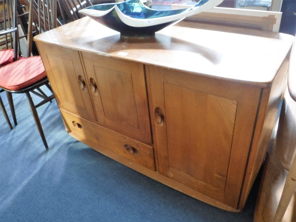 ERCOL: A PALE ELM SIDEBOARD fitted cupboards and a drawer, 45" wide