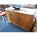 ERCOL: A PALE ELM SIDEBOARD fitted cupboards and a drawer, 45" wide