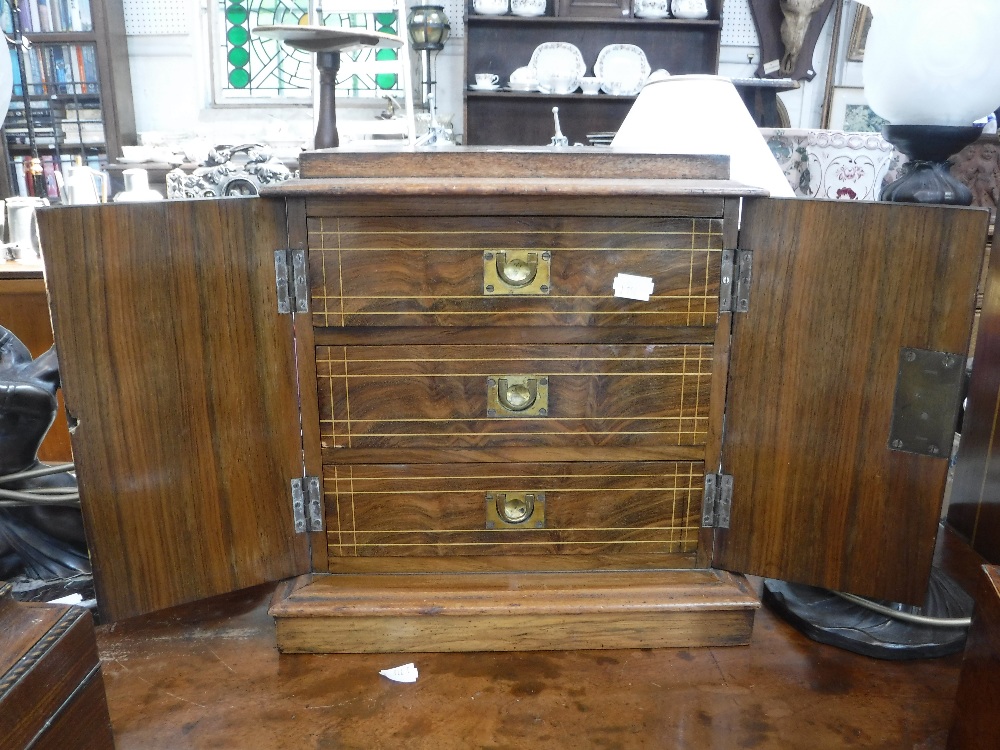 A VICTORIAN WALNUT TABLE CABINET with inlaid decoration, fitted three interior drawers behind a pair