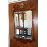 AN 18TH CENTURY WALNUT FRAMED WALL MIRROR with gilt gesso decoration and bevel glass plate, 37" high