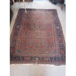 A RED GROUND PERSIAN RUG with blue borders, 57" x 79"