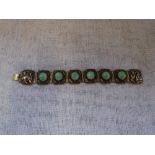 CHINESE SILVER: AN ORIENTAL CARVED BRACELET inset with cabochon-cut 'Jade' beads