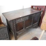 A 17TH CENTURY OAK COFFER, with a three panelled front and carved decoration, 28" high x 45" wide