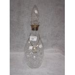 A SILVER MOUNTED GLASS DECANTER with a Victorian Irish silver label, in the form of an 'S' with