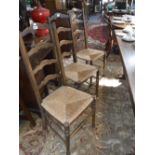 SEVEN LADDERBACK DINING CHAIRS with rush seats, including two carver chairs