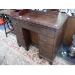 A GEORGE III MAHOGANY KNEEHOLE DESK with a baize lined brushing slide, central cupboard and flank