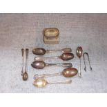 A COLLECTION OF SILVER TEASPOONS, a pair of small silver sugar tongs, a napkin ring and other items