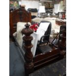 A VICTORIAN MAHOGANY SINGLE BEDSTEAD with heavily carved front columns (originally a larger bed)