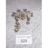 AN IBERIAN STYLE FLORAL DIAMOND BROOCH, the central flower surrounded by leaves and flower drops,