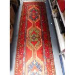 A RED GROUND PERSIAN RUNNER, 30" x 114"