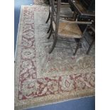 A LARGE BEIGE GROUND CARPET with pink border and all over foliate decoration, 106" x 138"