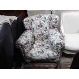 A VICTORIAN ARMCHAIR upholstered in floral material