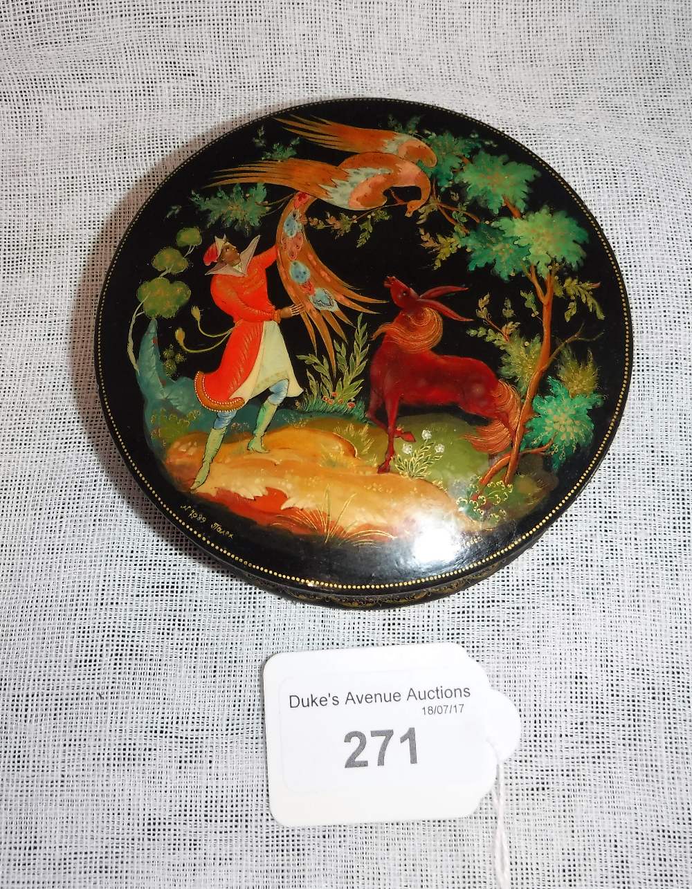 A RUSSIAN PAPIER MACHE AND PAINTED SNUFF BOX with a scene of a man with phoenix bird and horse