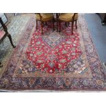 A RED GROUND PERSIAN DESIGN RUG with blue borders and floral motifs, 70" x 108"