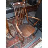 ERCOL: A STAINED ELM STICK-BACK ROCKING CHAIR