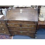 A GEORGE II OAK BUREAU with fitted interior and central well, 39" high x 33" wide