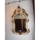 A CREAM AND GILT CARTOUCHE WALL MIRROR with hand-painted floral decoration, 35" high x 20.5" wide