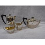 A GEORGE V SILVER AND SILVER PLATED FOUR PIECE TEASET in the Georgian style with fluted