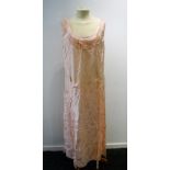 A FULL LENGTH LIGHT PINK NIGHTDRESS with tie waistline, the shoulders joined by three thin straps,