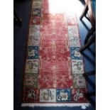A RED GROUND FLAT WEAVE RUNNER of traditional design, 31" x 123"